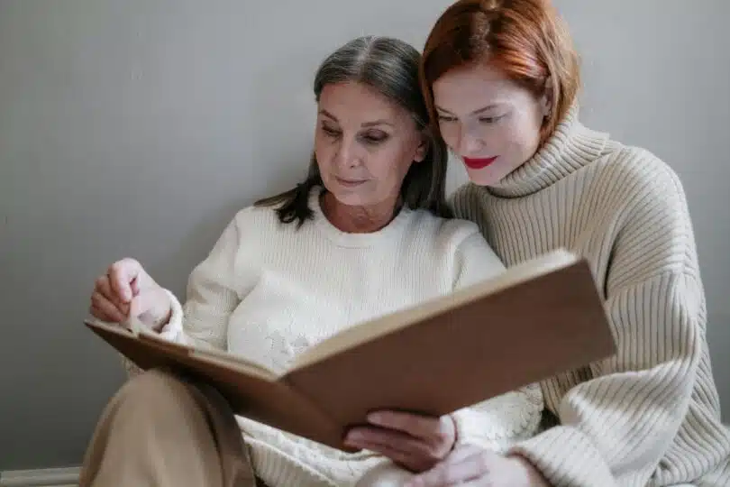 Une dame et sa petite fille regardant un album photo