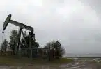 an oil pump sitting on top of a dirt field