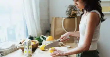 a woman cutting lemons on a cutting board