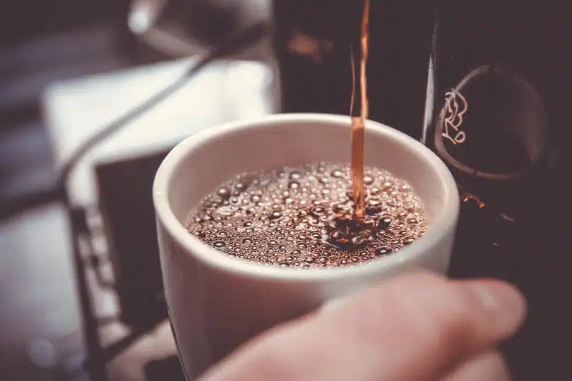 Un café qui coule dans une tasse blanche